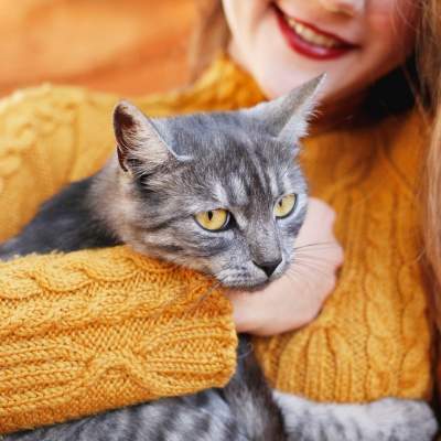 WOMEN HOLDING CAT IN HER ARMS